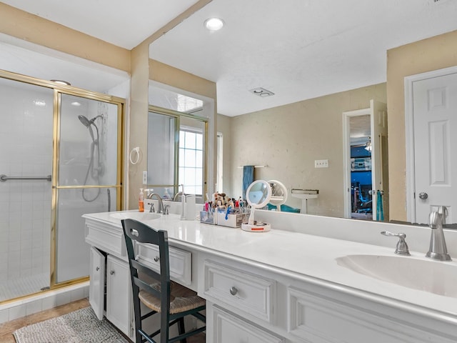 full bathroom featuring a sink, a shower stall, and double vanity
