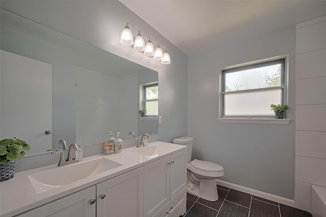 111 N 11th St, Highlands, TX 77562 - full bath featuring toilet, double vanity, baseboards, and tile patterned flooring
