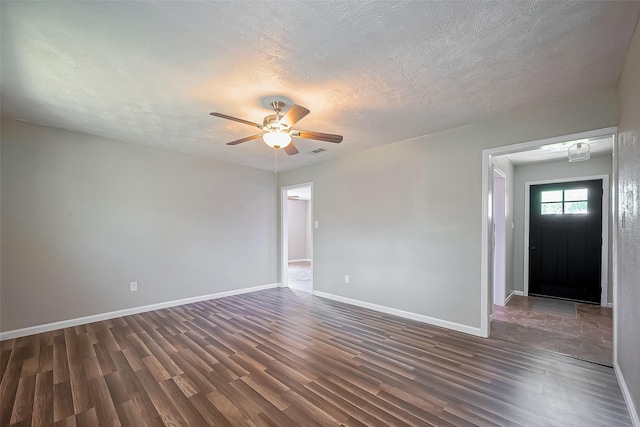 111 N 11th St, Highlands, TX 77562 - spare room featuring dark wood finished floors, a ceiling fan, a textured ceiling, and baseboards