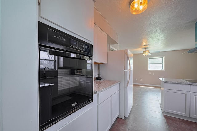 111 N 11th St, Highlands, TX 77562 - kitchen featuring a ceiling fan, a textured ceiling, freestanding refrigerator, tile patterned floors, and black electric stovetop