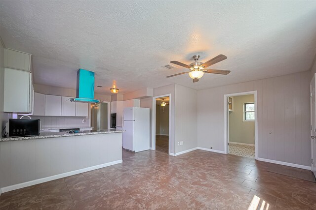 111 N 11th St, Highlands, TX 77562 - kitchen with black appliances, a ceiling fan, a peninsula, a textured ceiling, and light stone countertops