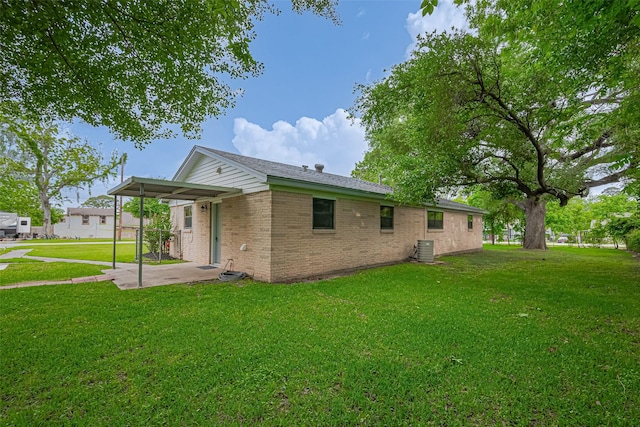 111 N 11th St, Highlands, TX 77562 - back of property with a yard, brick siding, central air condition unit, and a patio area
