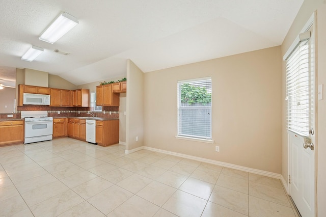 kitchen with backsplash, vaulted ceiling, visible vents, white appliances, and light tile patterned flooring