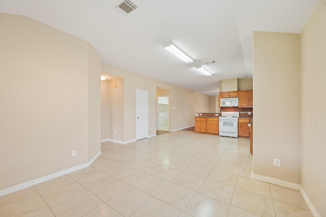 empty room featuring baseboards, visible vents, and light tile patterned floors