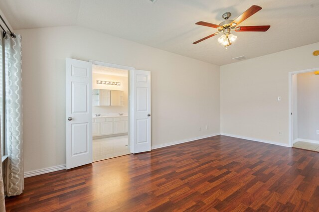 empty room with ceiling fan, vaulted ceiling, wood finished floors, and visible vents