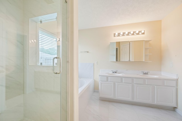 bathroom featuring a bath, a sink, a shower stall, and double vanity