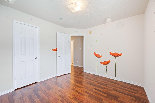 unfurnished bedroom with baseboards and wood finished floors