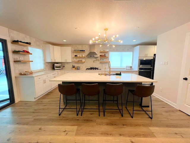 2906 Pecan Ridge Dr, Sugar Land, TX 77479 - kitchen featuring open shelves, wall chimney range hood, white cabinetry, light countertops, and recessed lighting