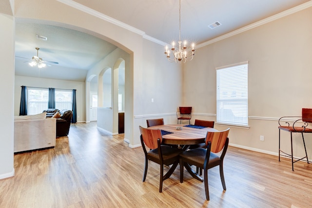 dining space featuring arched walkways, visible vents, light wood finished floors, and ceiling fan with notable chandelier
