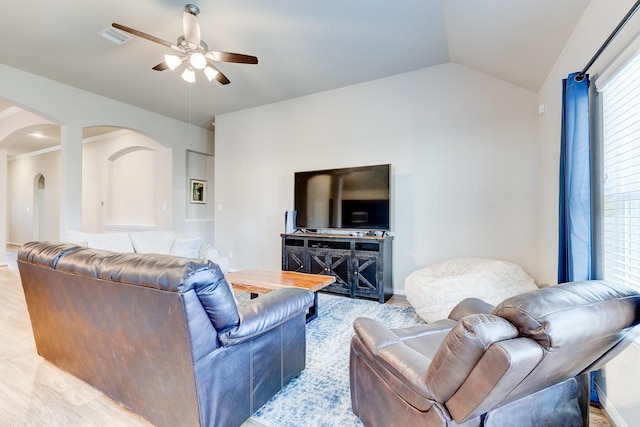 living room with arched walkways, ceiling fan, visible vents, and lofted ceiling