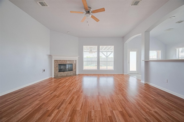 19915 Hardsville Dr, Spring, TX 77388 - unfurnished living room with light wood-type flooring, a premium fireplace, a ceiling fan, baseboards, and vaulted ceiling