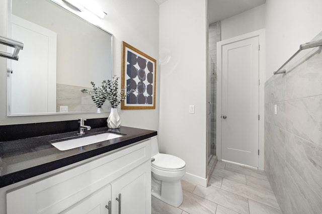 bathroom with tile walls, tile patterned flooring, a stall shower, vanity, and toilet