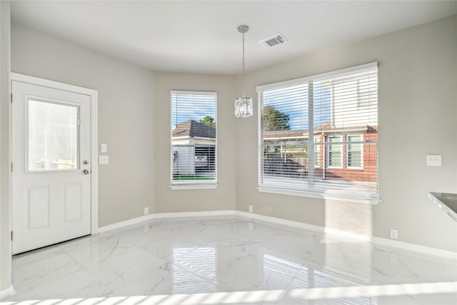 unfurnished dining area featuring an inviting chandelier, marble finish floor, baseboards, and visible vents