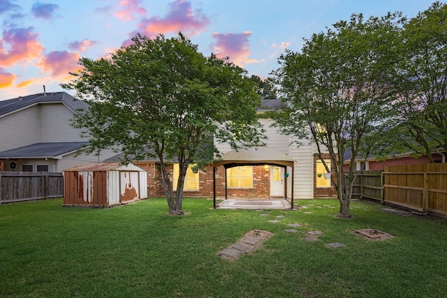 back of property with a patio, a lawn, a shed, and a fenced backyard