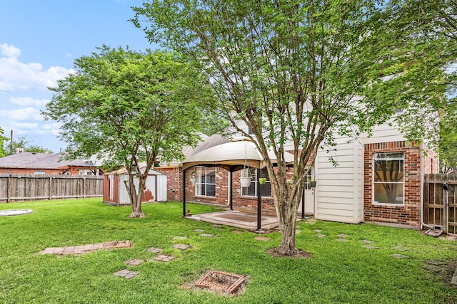 rear view of house featuring a fenced backyard, brick siding, a yard, and a storage unit
