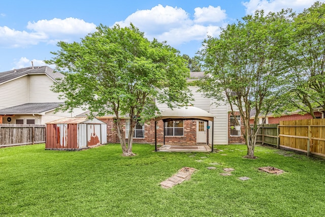 back of property with a fenced backyard, a storage shed, an outdoor structure, a gazebo, and brick siding