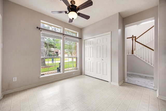 unfurnished bedroom featuring a closet, tile patterned floors, baseboards, and a ceiling fan