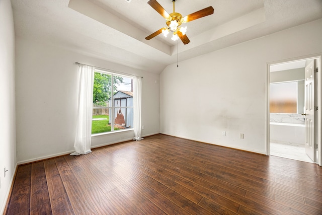 spare room featuring hardwood / wood-style floors, ceiling fan, baseboards, and a raised ceiling