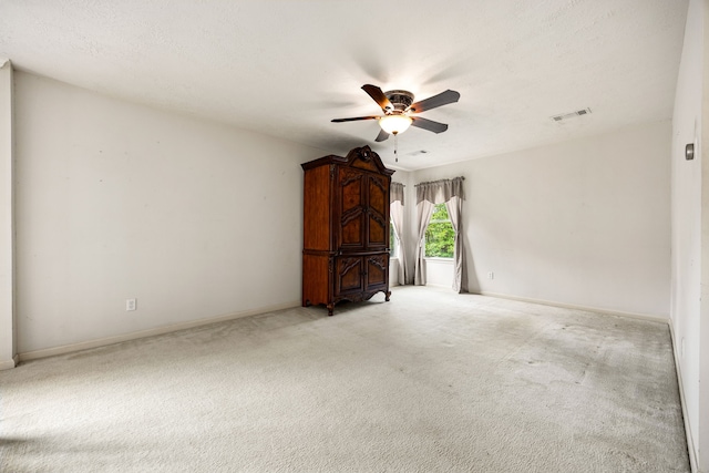 unfurnished living room featuring visible vents, a ceiling fan, baseboards, and light carpet
