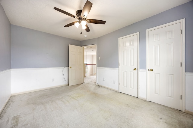 unfurnished bedroom with baseboards, carpet flooring, and ceiling fan