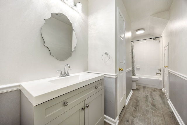 full bath with toilet, baseboards, wood finished floors, vanity, and shower / tub combination