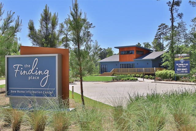 community sign featuring concrete driveway