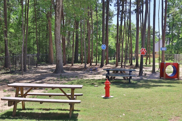 view of property's community featuring a yard and fence