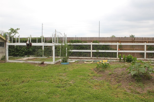 view of yard featuring fence and a garden