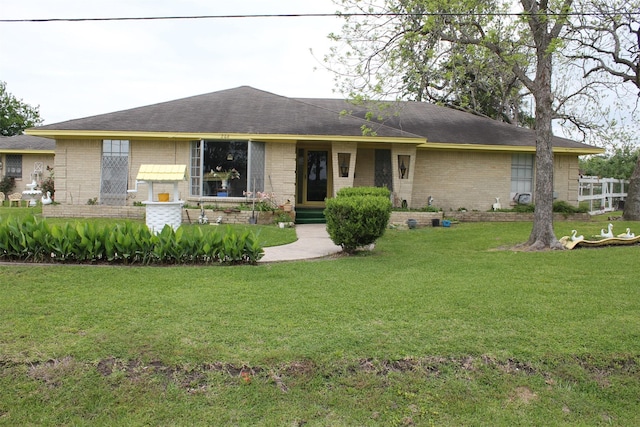 view of front of home with a front lawn and brick siding