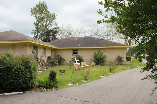 view of front of property with a front lawn and brick siding