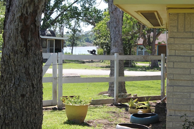 view of yard with a water view and fence