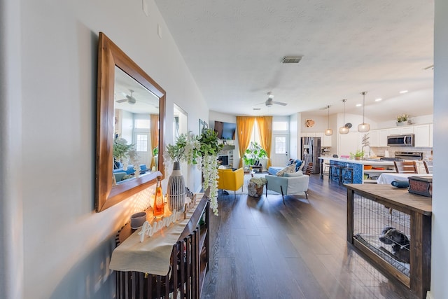interior space featuring dark wood-style floors, visible vents, and ceiling fan