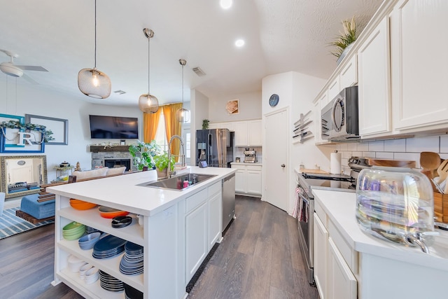 kitchen featuring tasteful backsplash, open shelves, a sink, appliances with stainless steel finishes, and white cabinetry