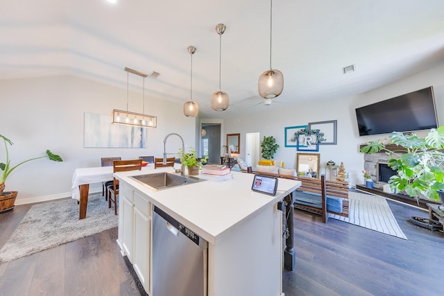 kitchen featuring white cabinets, a sink, open floor plan, light countertops, and stainless steel dishwasher