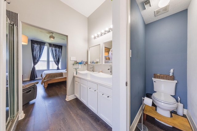 ensuite bathroom with visible vents, toilet, ensuite bath, and wood finished floors
