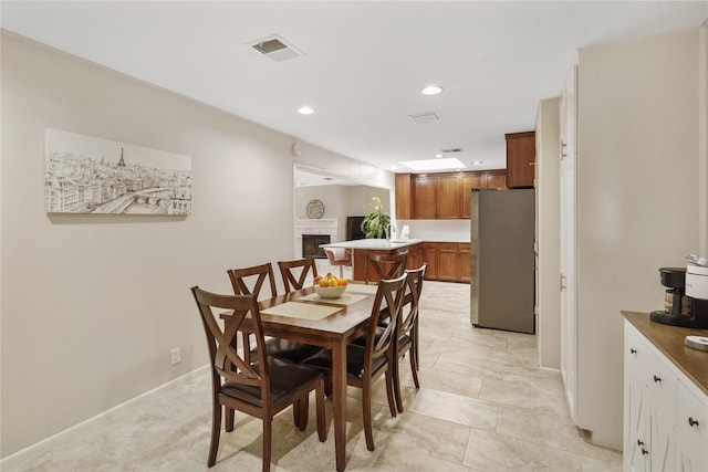 dining area featuring baseboards, a fireplace, visible vents, and recessed lighting