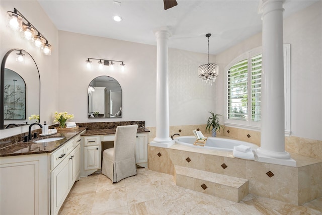 bathroom with a bath, a notable chandelier, vanity, and ornate columns