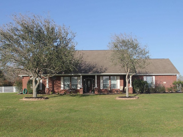 ranch-style house with fence, a front lawn, and brick siding