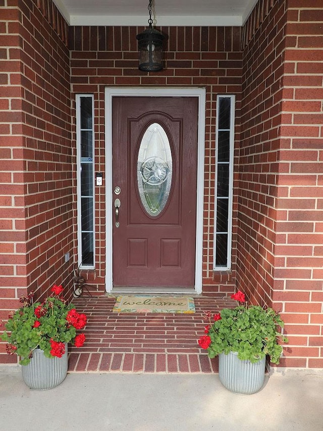 property entrance featuring brick siding