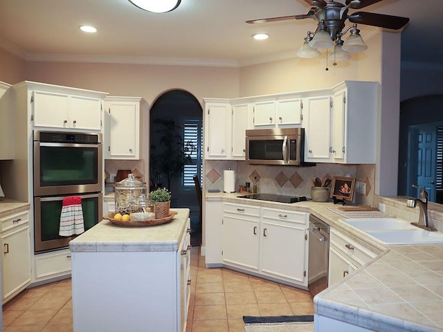 kitchen with crown molding, ceiling fan, appliances with stainless steel finishes, and a sink