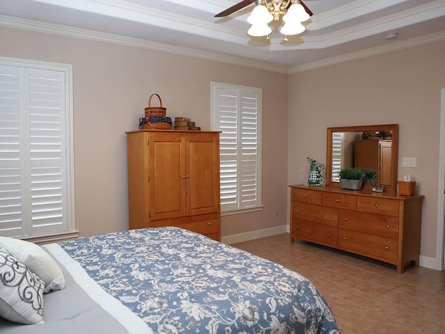bedroom with ceiling fan, crown molding, baseboards, a tray ceiling, and light tile patterned flooring