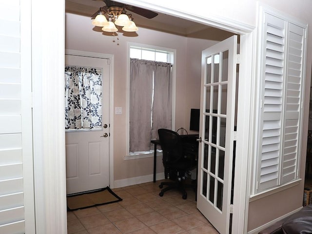 interior space with light tile patterned flooring, ceiling fan, and baseboards