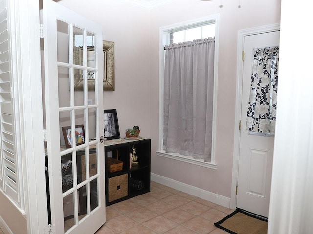 doorway with baseboards and tile patterned floors