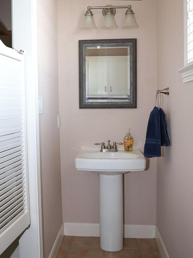 bathroom with baseboards and tile patterned flooring