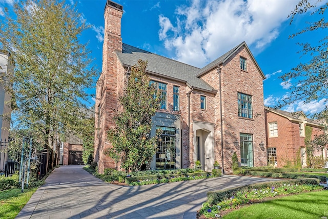 3028 Locke Ln, Houston, TX 77019 - traditional-style home featuring brick siding, a chimney, and a shingled roof