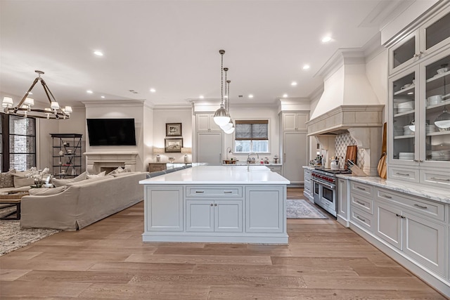3028 Locke Ln, Houston, TX 77019 - kitchen with ornamental molding, a chandelier, open floor plan, light wood-style floors, and range with two ovens