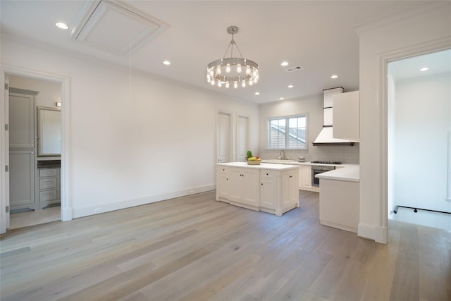 3028 Locke Ln, Houston, TX 77019 - kitchen featuring a sink, a kitchen island, light wood-style flooring, light countertops, and ornamental molding