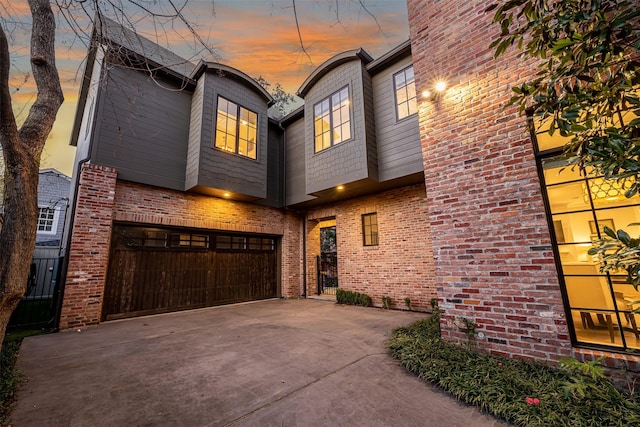 3028 Locke Ln, Houston, TX 77019 - view of front of house featuring driveway, an attached garage, and brick siding