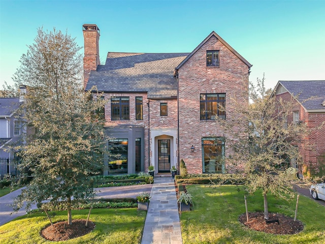 3028 Locke Ln, Houston, TX 77019 - view of front of home featuring brick siding, a chimney, a front lawn, and a high end roof