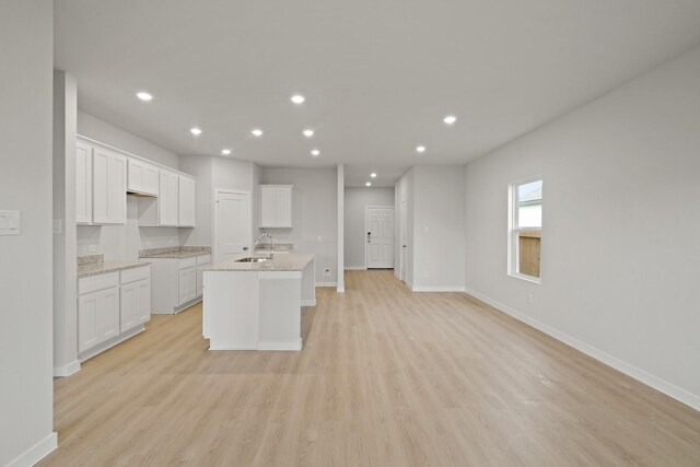 17824 Lionheart Rd, Conroe, TX 77306 - kitchen with baseboards, recessed lighting, light wood-style flooring, and a center island with sink